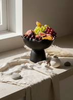 Fruit bowl with fruits on a table with a neutral background