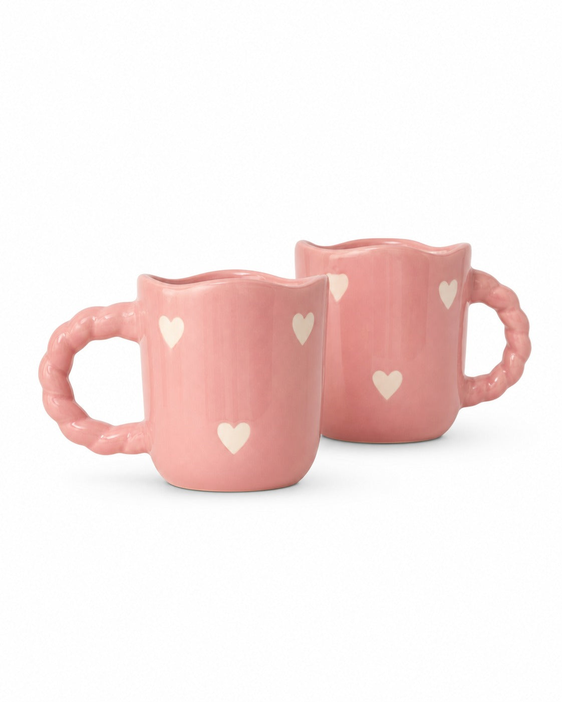 Two pink ceramic mugs with scalloped handles and small white heart details, shown on a clean white background.