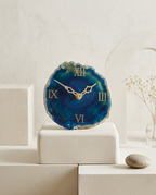 Decorative clock with blue agate-like face on a white surface