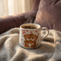 Cup of coffee with teddy bears and 'Love you' text on a textured surface