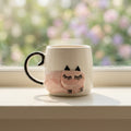 Ceramic mug with a cat design on a windowsill with a blurred outdoor background