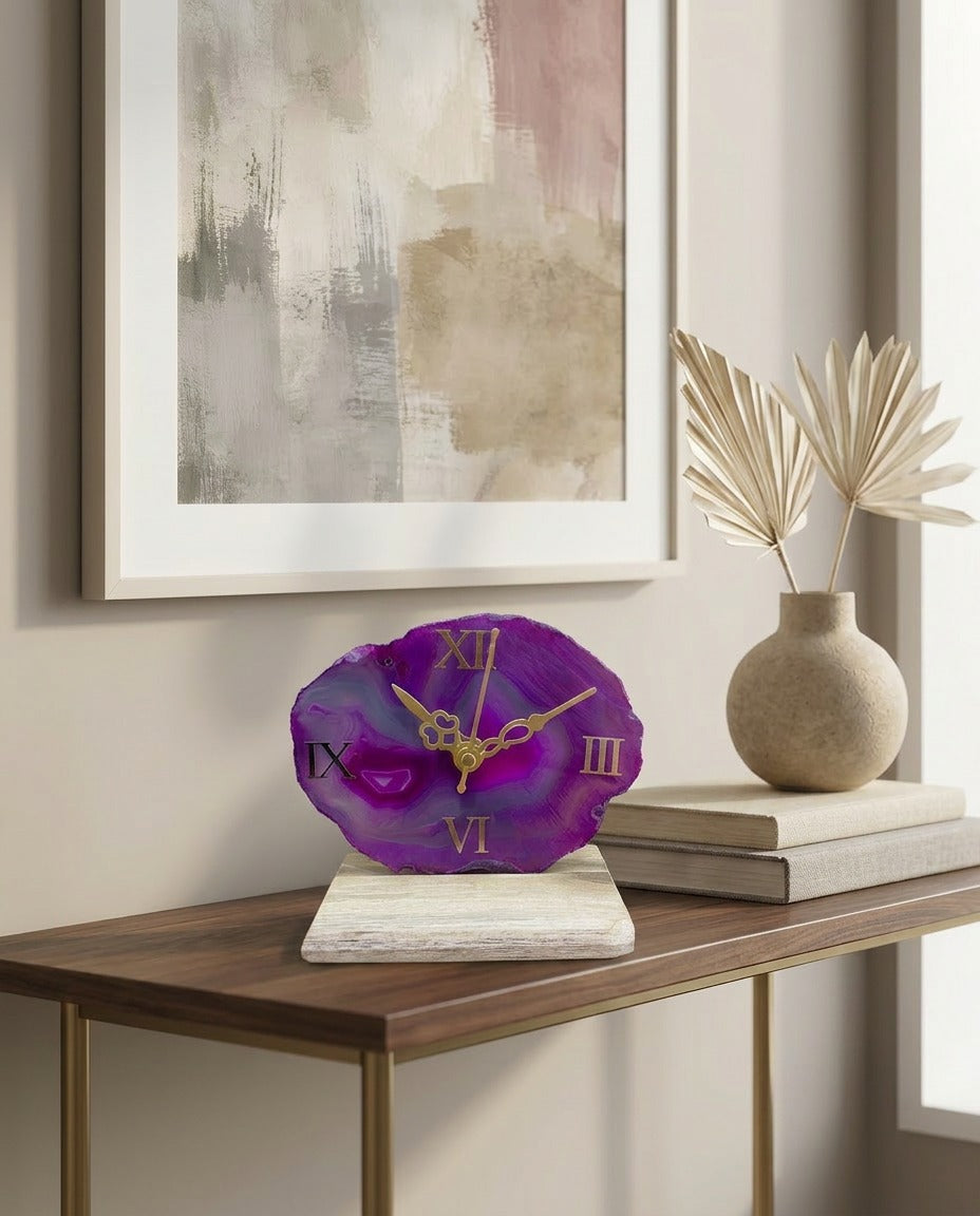 Purple clock on a wooden table with abstract art and decor in the background