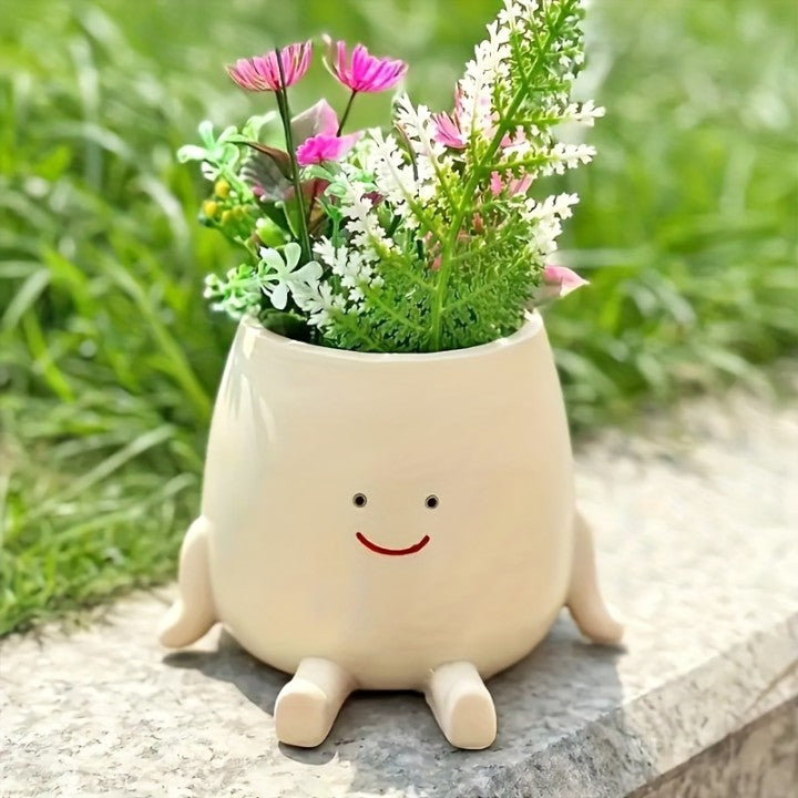 Cute white planter with a face, filled with flowers, on a natural background