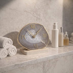 Decorative clock on a marble surface with towels and skincare products in the background