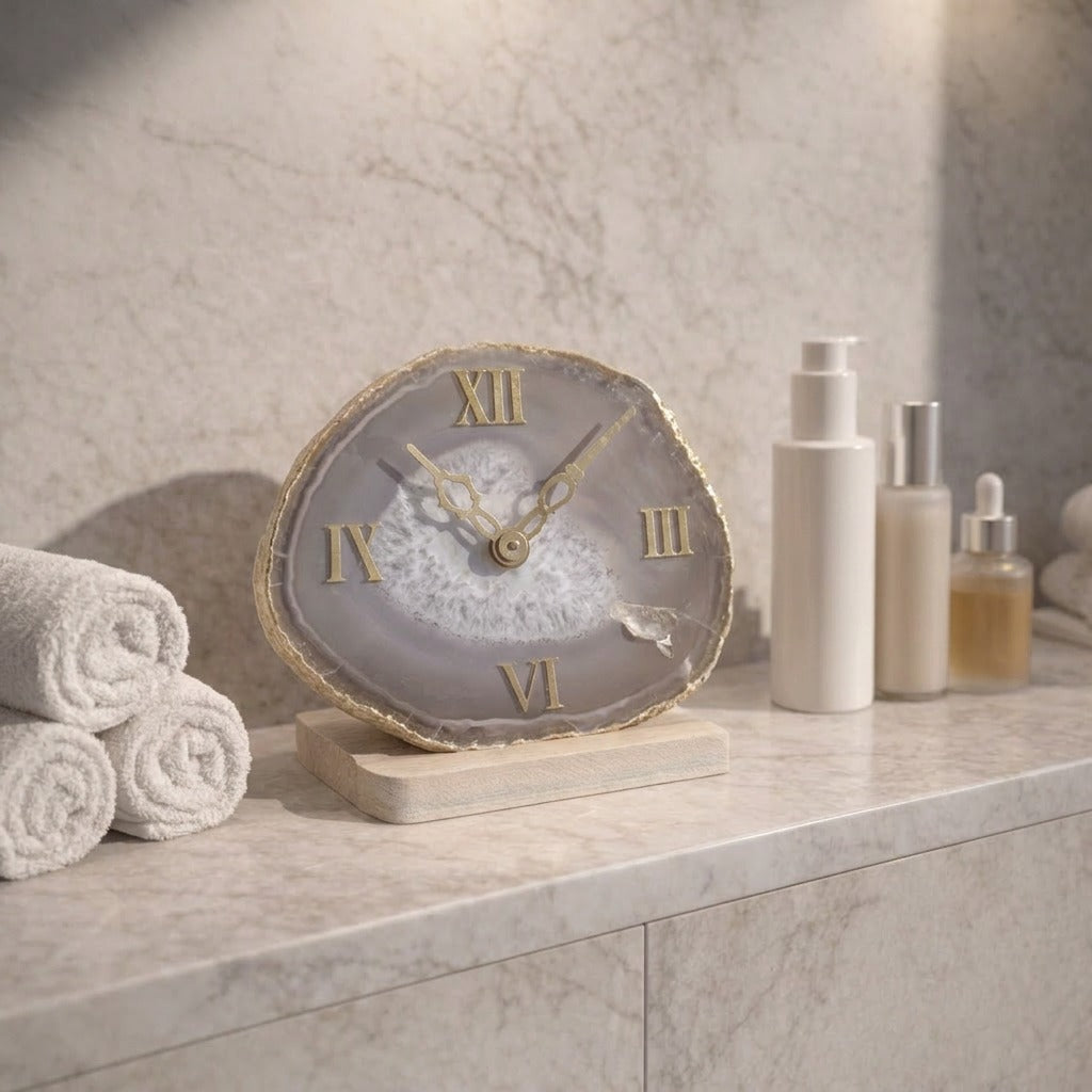 Decorative clock on a marble surface with towels and skincare products in the background
