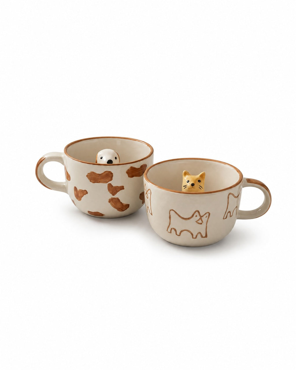 Two ceramic cat-themed mugs on a white background. One mug features brown cat silhouettes and a small white cat figurine inside, while the other features brown outline cat drawings and a small orange tabby cat figurine inside.