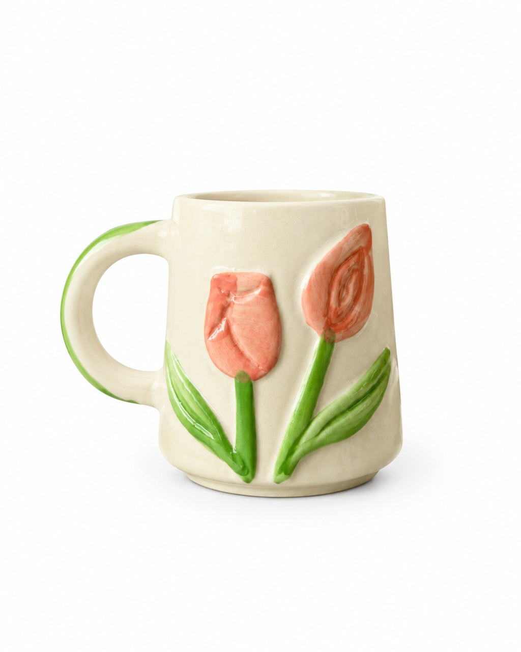 An off-white ceramic mug featuring a raised relief design of two pink tulips with green stems and leaves, and a green handle.