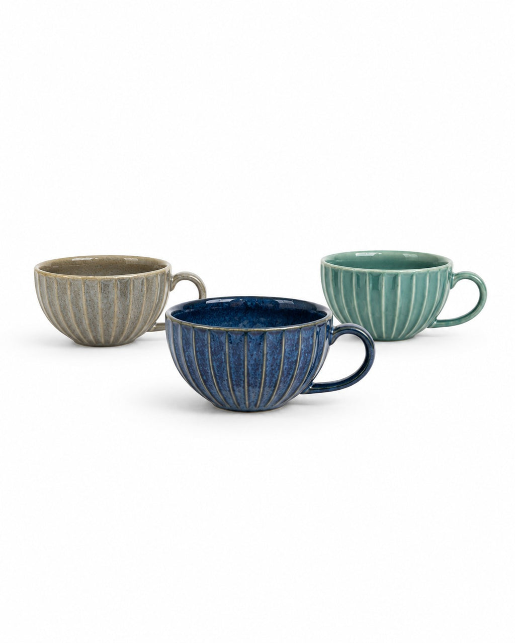 Three ribbed ceramic cups in beige, deep blue, and mint green, arranged on a clean white background.