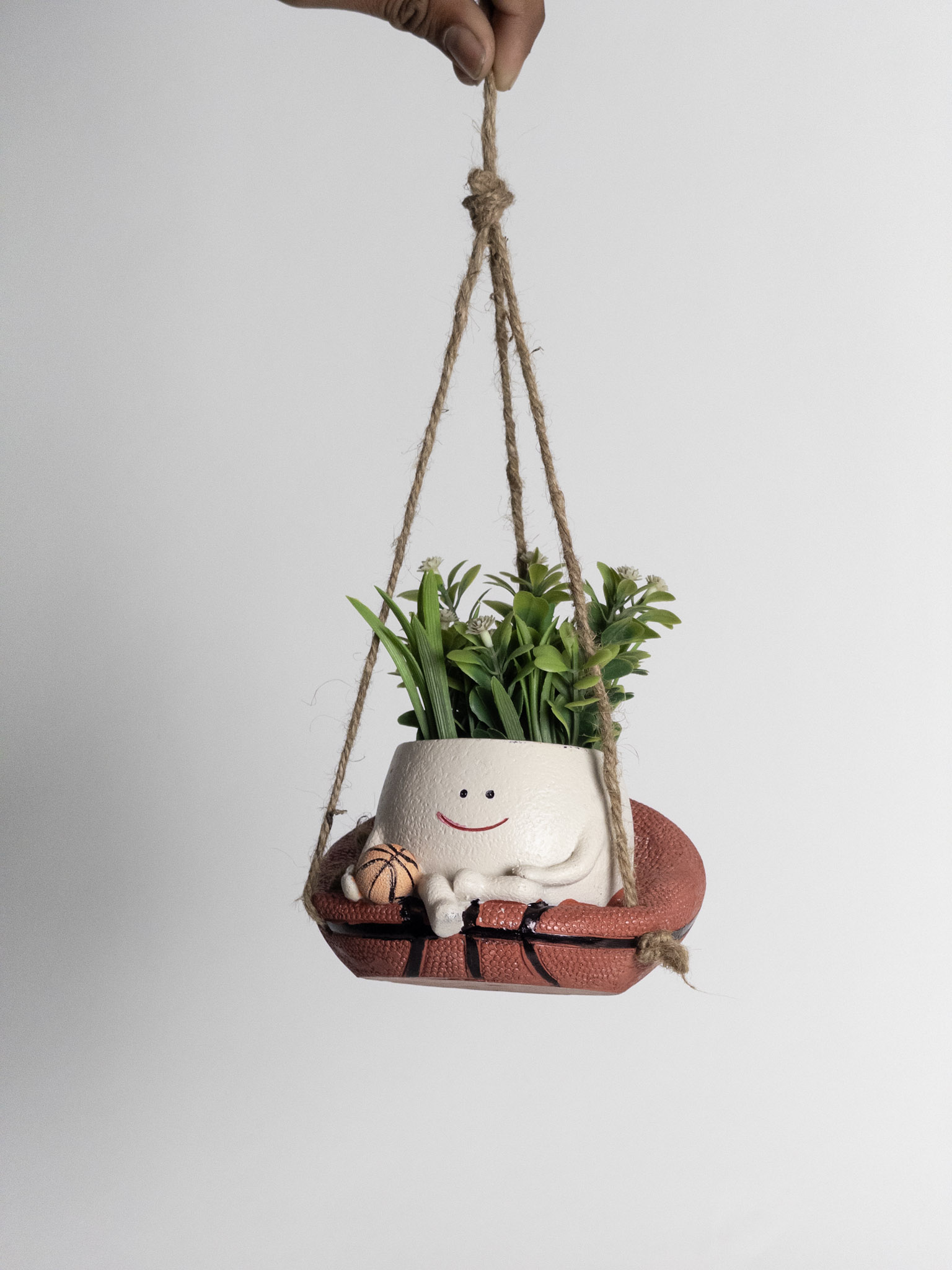 Hanging planter with a smiley face design on a white background