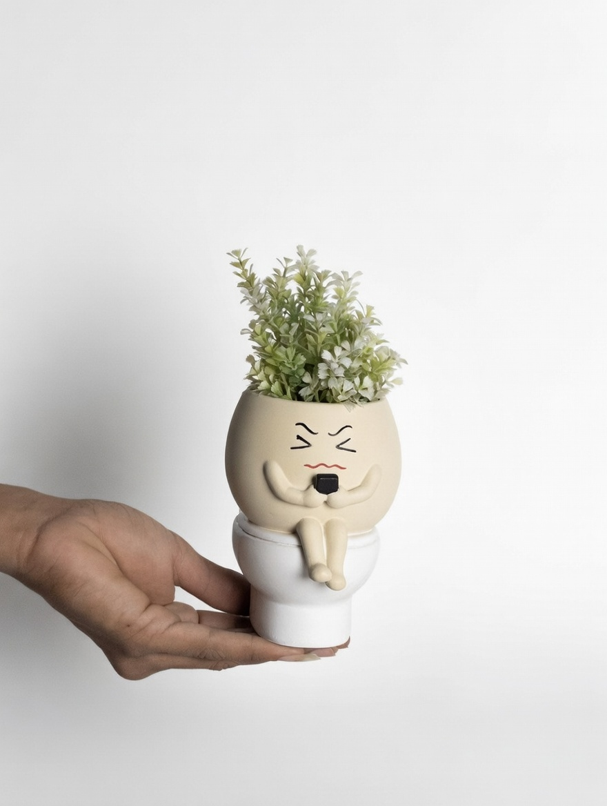 Hand holding a unique plant pot with a face design on a white background