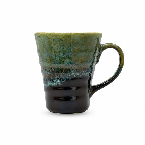 A ceramic mug with a textured, rustic glaze that transitions from olive green and teal at the top to a glossy black at the bottom, set against a plain white background.