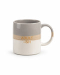 A ceramic coffee mug with a horizontal color-blocked design featuring a gray top half, a textured beige middle band with the text 'ADULT -ISH' in gold, and a white bottom half.