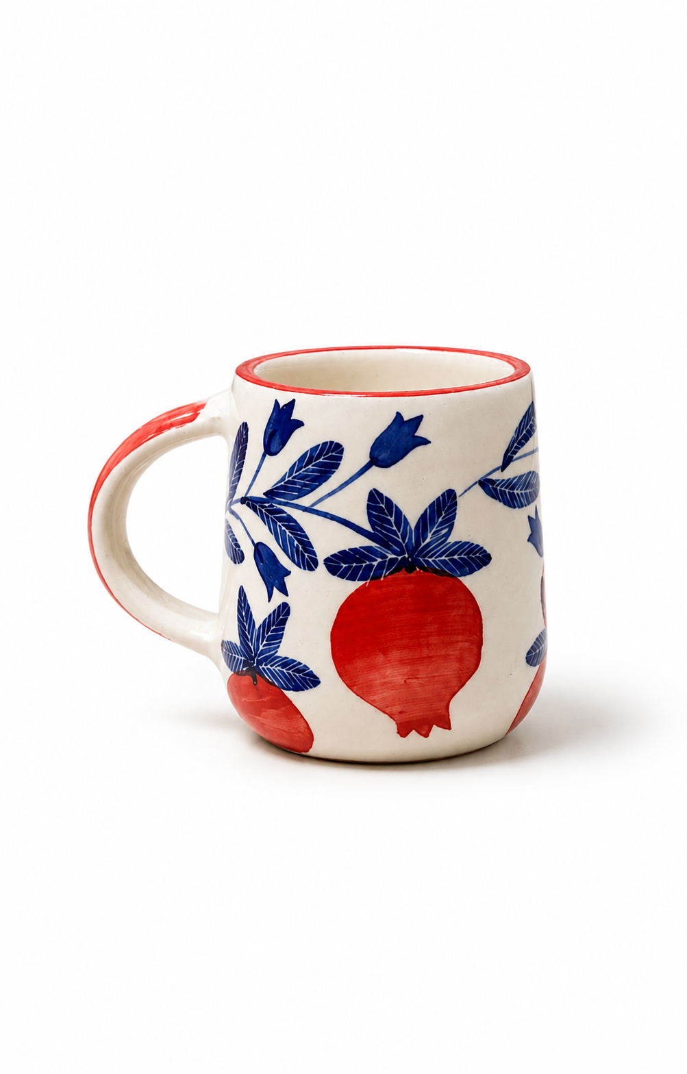 A white ceramic mug featuring a blue floral pattern and red pomegranate motifs, with a red handle and rim, shown on a white background.