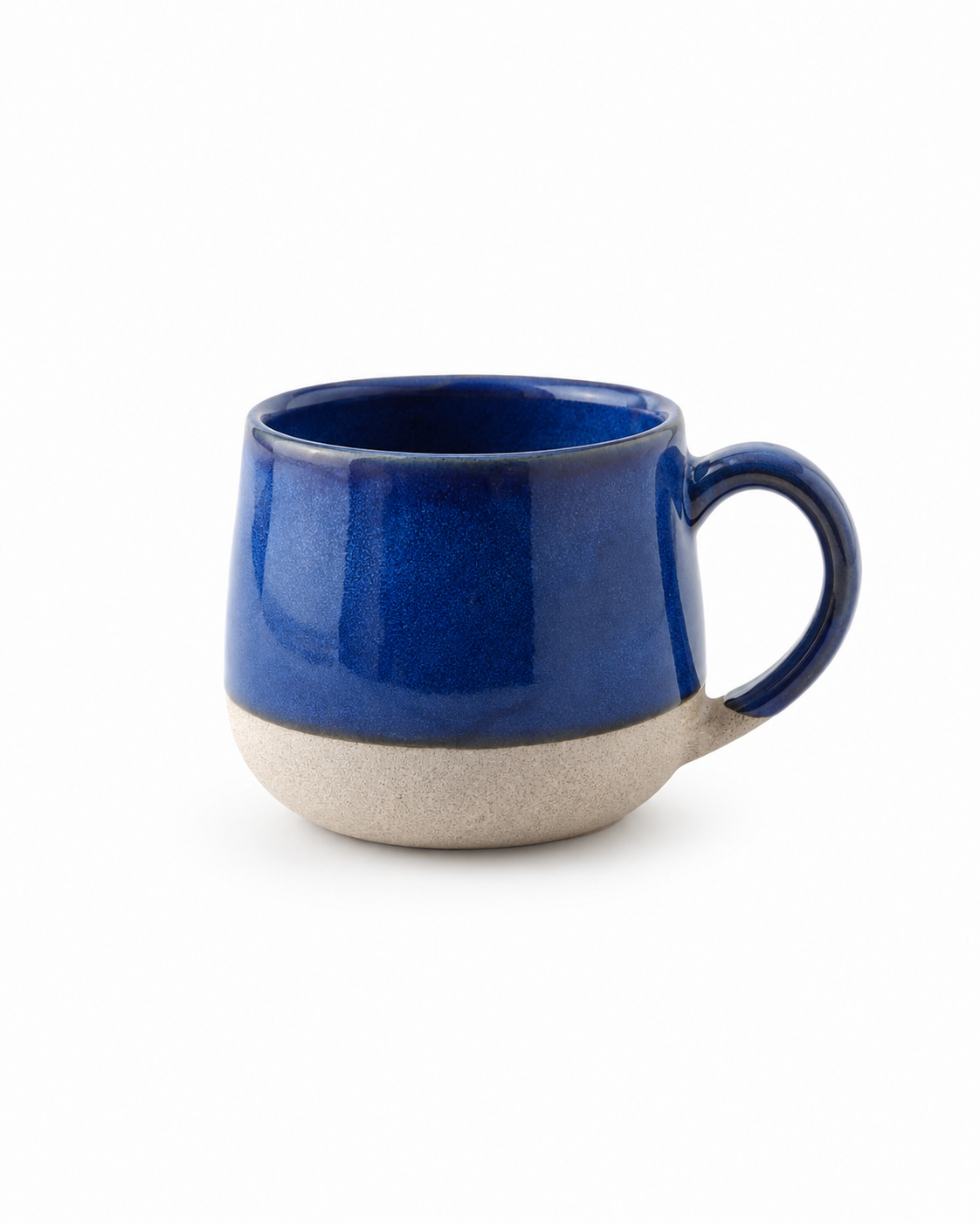 A ceramic coffee mug with a glossy deep blue upper body and handle, and a textured, unglazed beige lower base, shown on a plain white background.