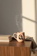 Steaming mug on a wooden surface with books and a lamp in the background