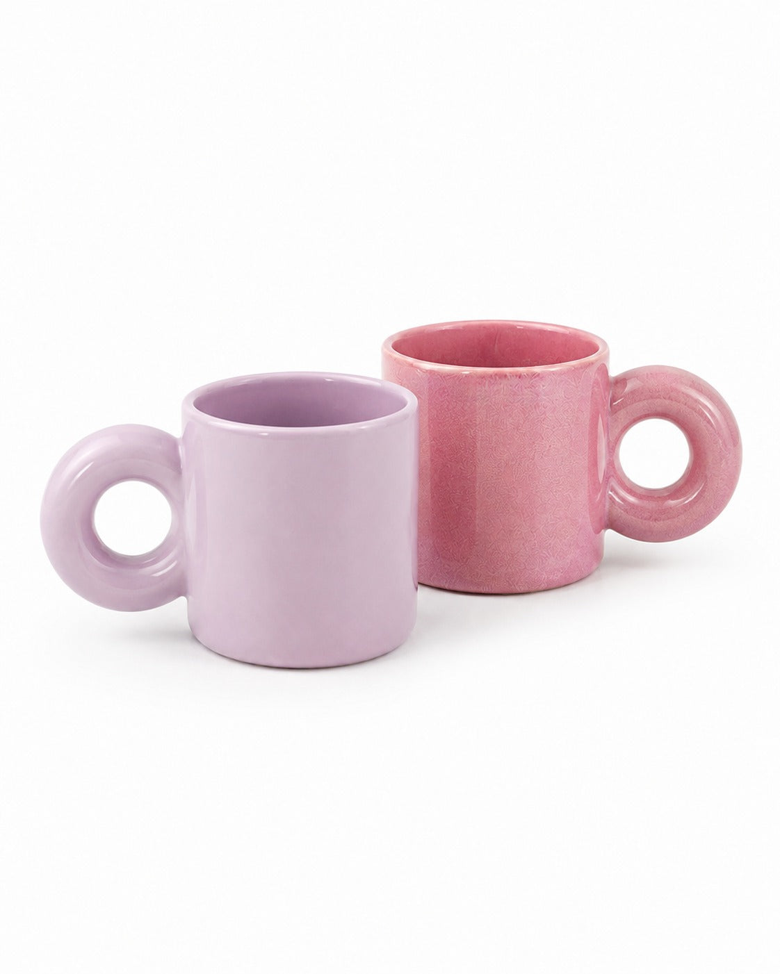 Two ceramic mugs with loop handles in pastel pink and lavender purple, shown on a clean white background.
